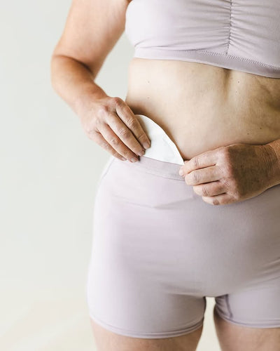 Person wearing light purple underwear against a plain background